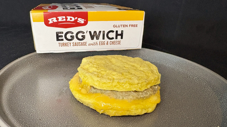 egg breakfast sandwich on plate in front of box