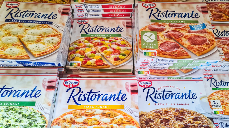 cardboard boxes of dr. oetker pizzas stacked and lined up in supermarket freezer, flavors like quattro formaggi, pizza funghi, and pizza salame