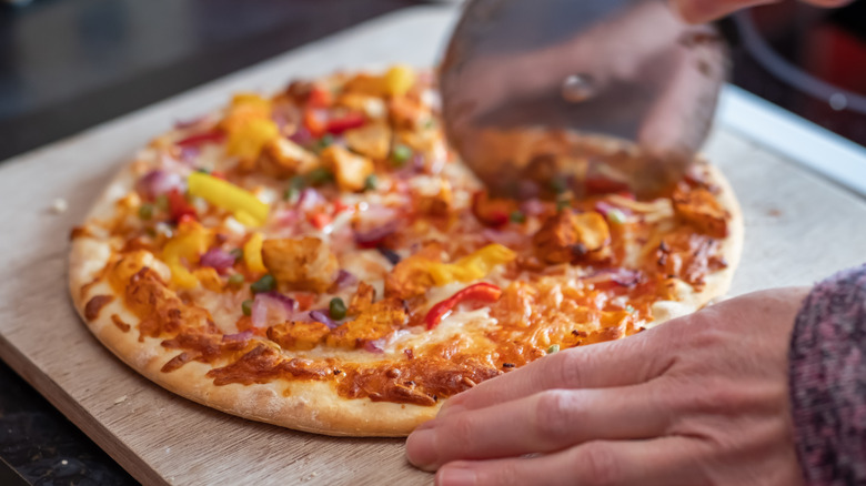 slicing a cooked frozen pizza