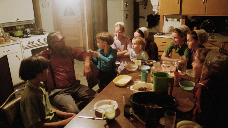 Amish family eating in kitchen.