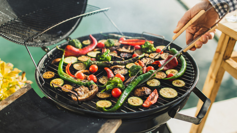 man grilling peppers and zucchini