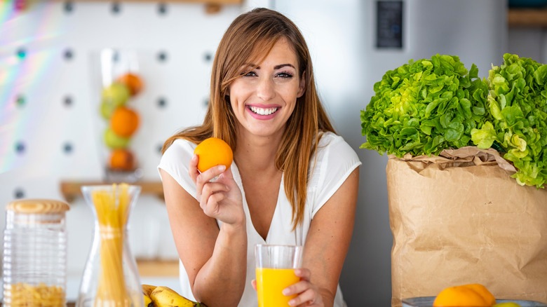 woman smiling holding an orange
