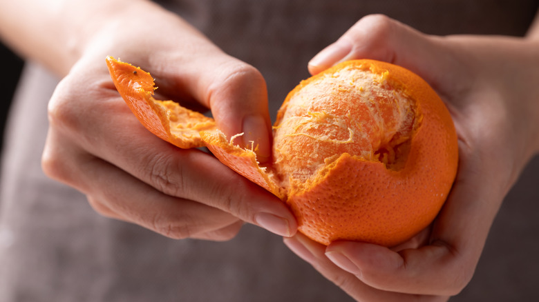 Hands peeling an orange