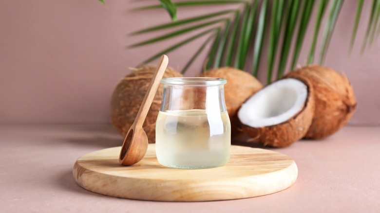 jar of melted coconut oil on wooden board 