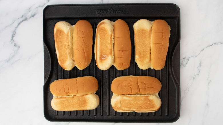 Hot dogs buns face-down on grill pan