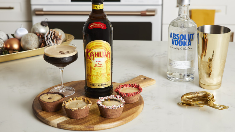 Completed cocktails in cocoa cups and bottles of alcohol