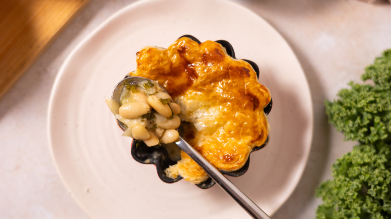 pot pie on plate with spoon of cannellini beans 