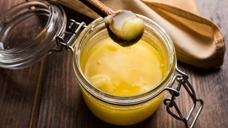 A glass jar of ghee with lid open 