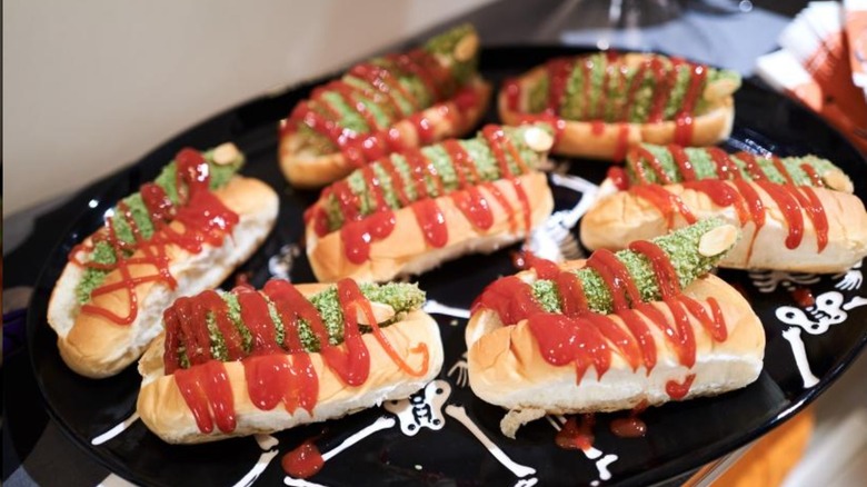 Green chicken fingers in hot dog buns with ketchup