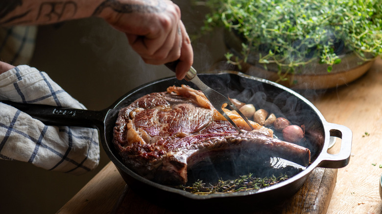A cooked steak in a cast-iron pan
