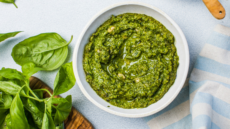 Pesto sauce next to basil leaves