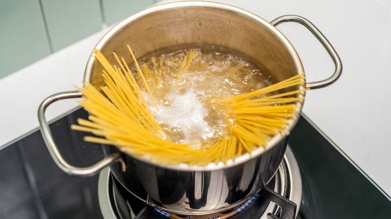 Spaghetti starting to cook in a tall pot