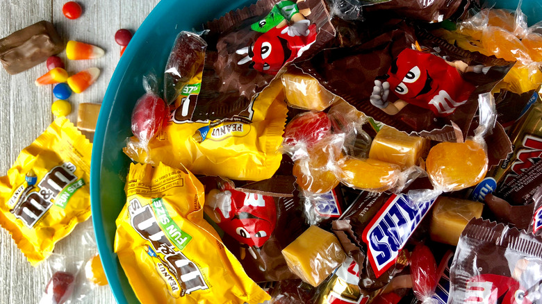 Bowl filled with M&Ms, Snickers, and other assorted candies