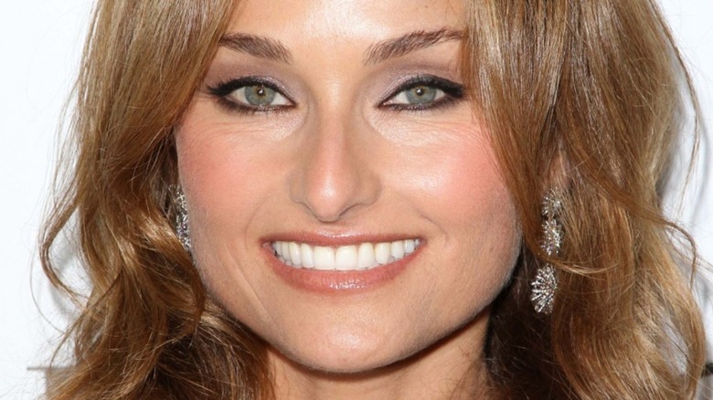 Giada De Laurentiis smiling with long earrings and loose hair