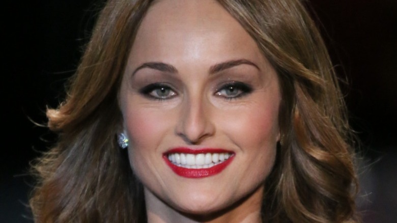 Giada De Laurentiis smiling with red lipstick on