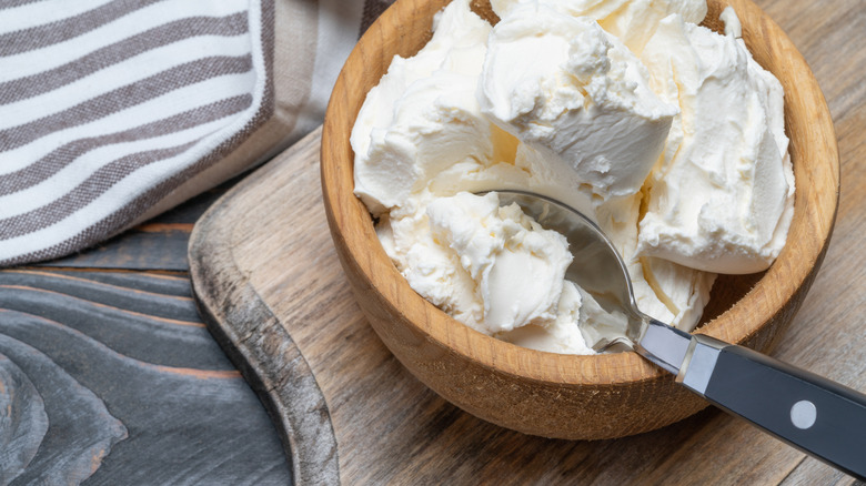 Mascarpone cheese in a wooden bowl with spoon