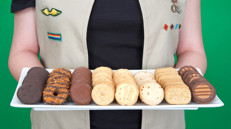 Girl Scout holding platter of Girl Scout cookies