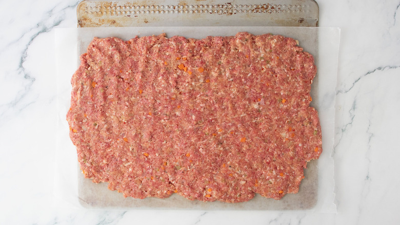 Meatloaf mixture pressed out onto wax paper sheet