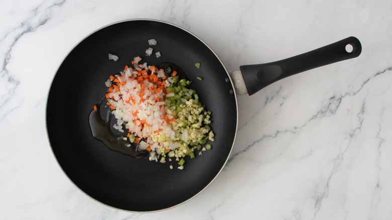 Minced mirepoix veggies in skillet