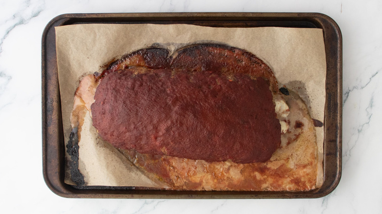 Baked sauce-coated meatloaf on baking sheet