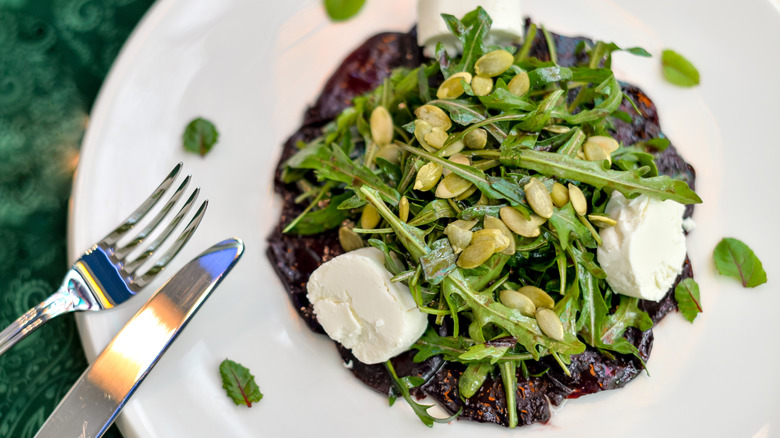 Salad with arugala, pumpkin seed, cheese, and beets