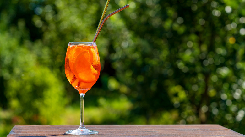 Aperol spritz outside on table with straws