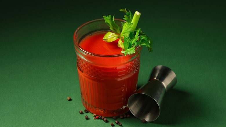 A bloody mary cocktail on green background