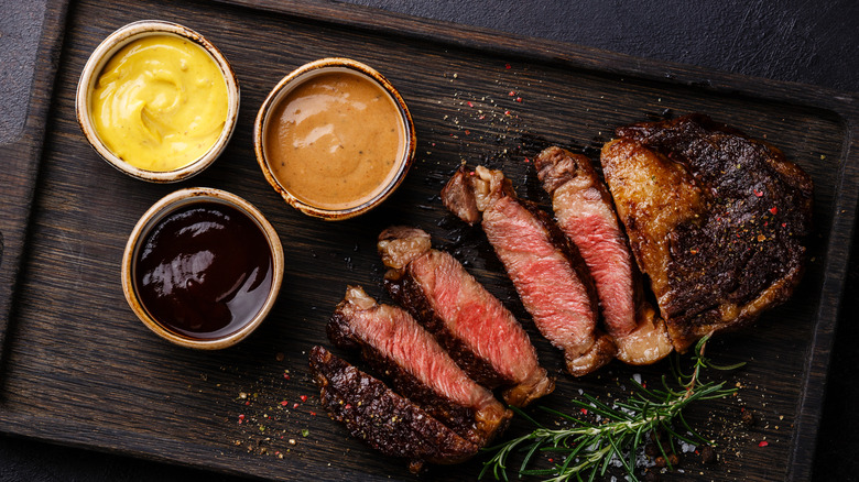 Steak with mustard, barbecue sauce, and pepper sauce
