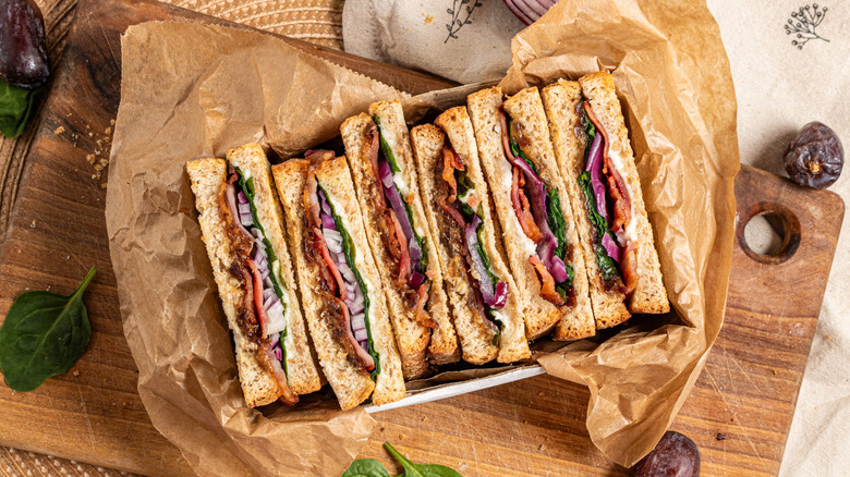 Goat cheese, bacon, and date panini slices in a box