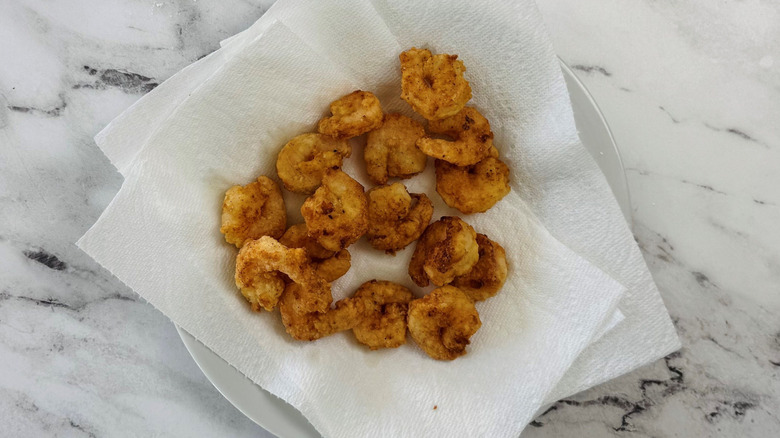 Fried shrimp on paper towel-lined plate