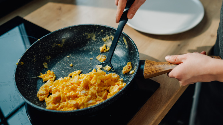 Person making scrambled eggs