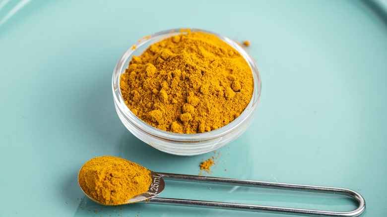 Bowl and spoon of ground turmeric