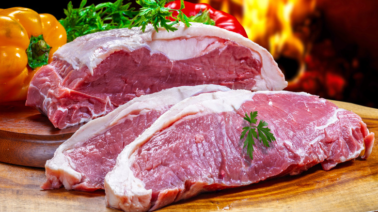 Uncooked sirloin steak on cutting board
