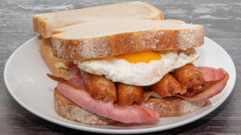 English bacon and sausage in a breakfast sandwich with egg