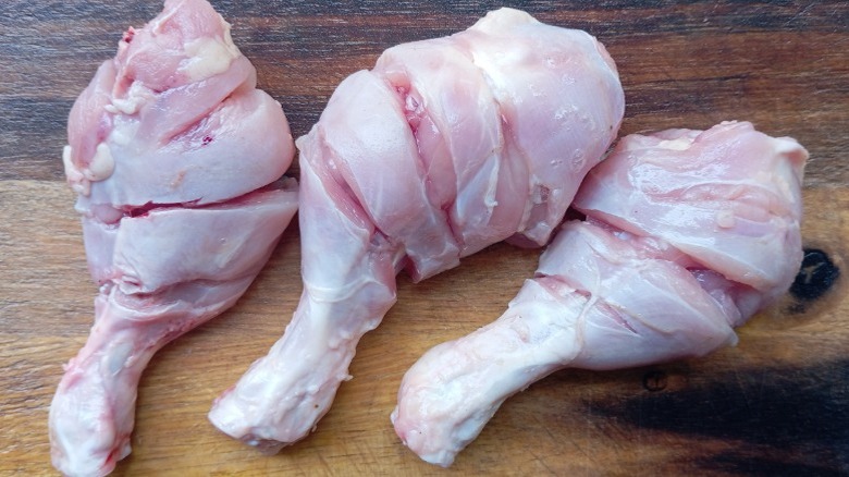 Three scored chicken drumsticks