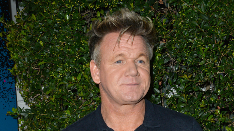 Gordon Ramsay standing in front of hedge