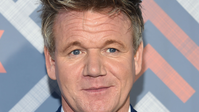 Gordon Ramsay against a blue and pink backdrop