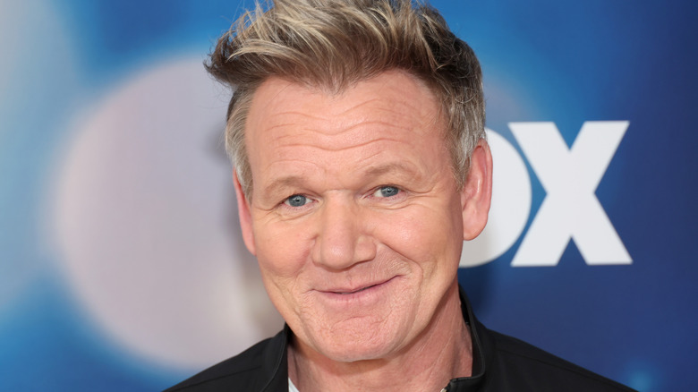 chef Gordon ramsay smiling for cameras at publicity event