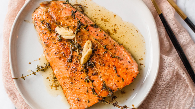 cooked salmon with garlic on plate from above