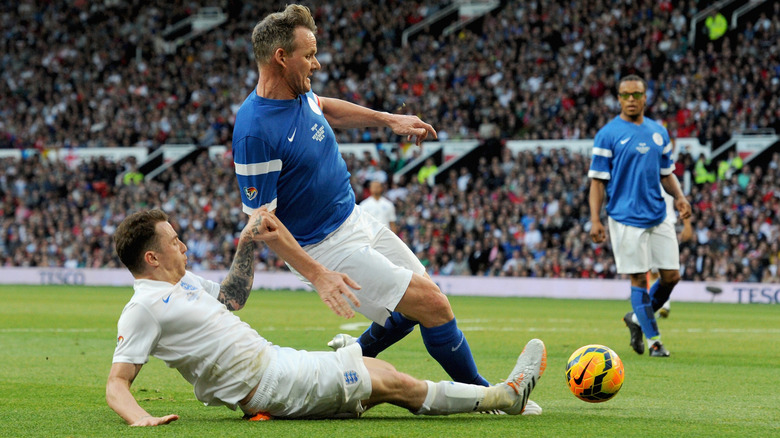 Danny Jones of England tackles Gordon Ramsay of the Rest of the World during Soccer Aid 2014