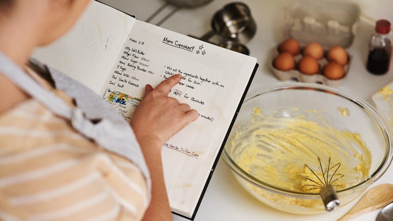 person baking cake from scratch using old recipe