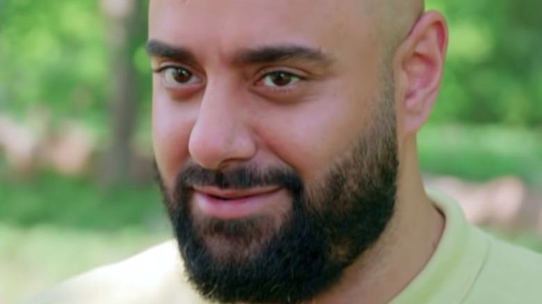 George Aristidou smiles in a lime green shirt