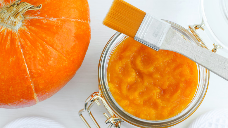 A bowl of pumpkin puree next to pumpkin