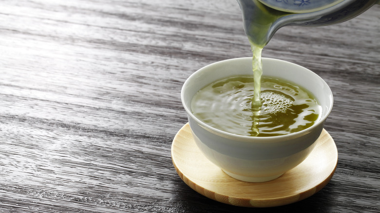 Green tea being poured into a cup