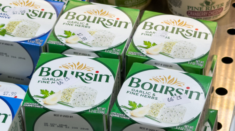 Boxes of garlic and fine herbs-flavored Boursin sit in the refrigerated section at the grocery store.