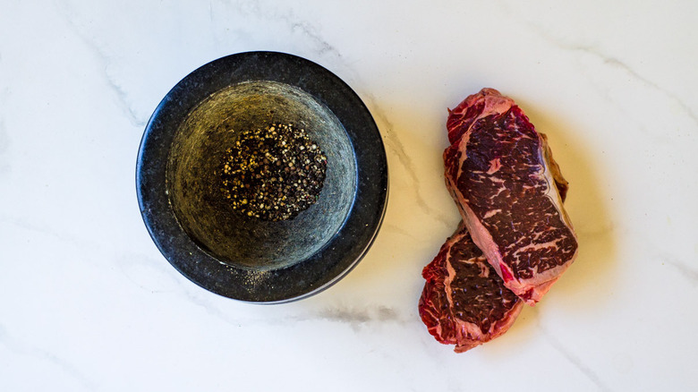 peppercorns and raw steaks
