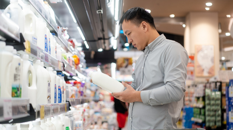 Man considering milk in supermarket