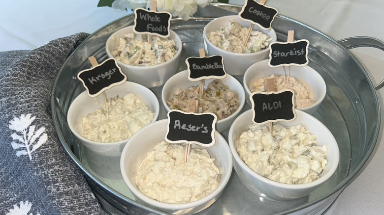 Tray of the chicken salads tested, each in a white bowl with a label