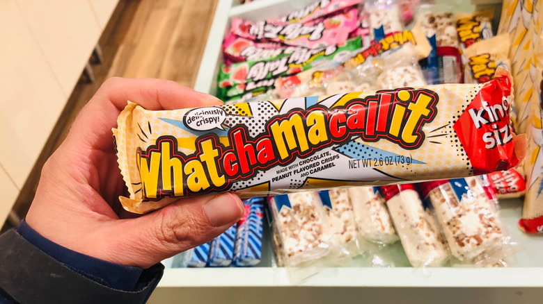 Close up of hand holding king size whatchamacallit candy bar