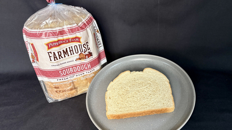 Bagged loaf of Pepperidge Farm Sourdough next to slice of bread on gray plate